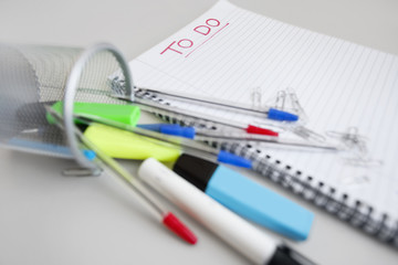 Close-up view of spiral notebook with to-do list and office supplies