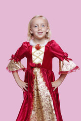 Portrait of a happy young girl dressed in princess costume over pink background