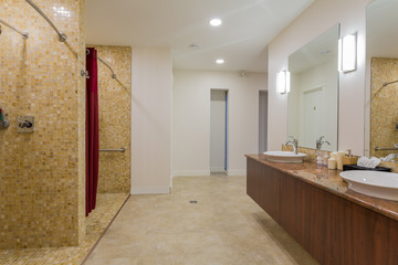 Spa or sauna modern bathroom with shower, white sinks and stone counter top.