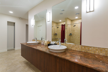 Spa or sauna modern bathroom with shower, white sinks and stone counter top.