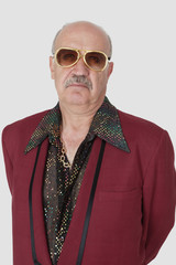Portrait of unhappy senior man wearing sunglasses against gray background