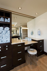 Interior of modern bathroom with cabinets and stool