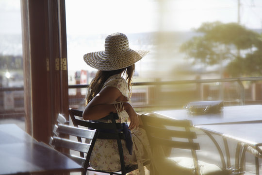 Rear View Of Young Woman Wearing Sunhat At Cafe