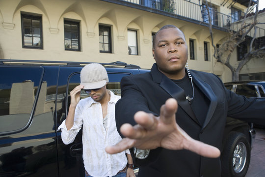 Male Celebrity With His Bodyguard Against A Vehicle