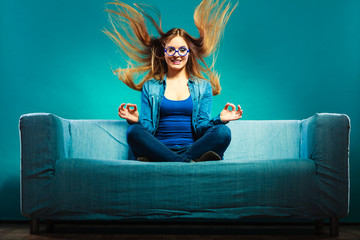 Fashionable girl wearing denim sitting on couch.