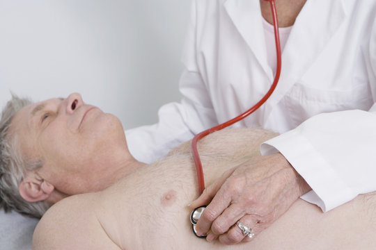 Senior female doctor testing patients heartbeat using stethoscope at the clinic