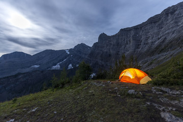 Illuminated tent camping on ridgeline of mountain