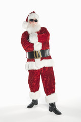 Portrait of a man dressed in Santa Claus outfit wearing sunglasses isolated over white background