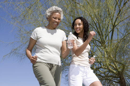 Happy African American mother and daughter jogging together