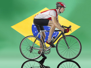 Male Cyclist cycling in front of Brazilian Flag