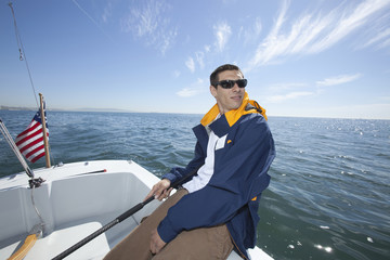 Young mixed race man sailing in boat