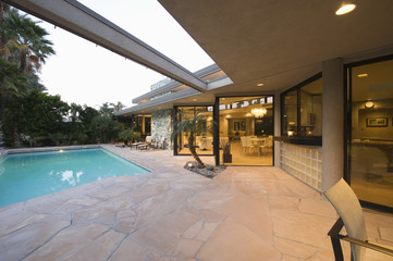 View of swimming pool and illuminated modern home exterior