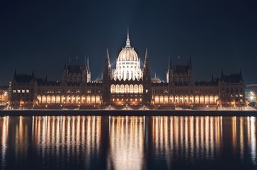 Obraz premium Night cityscape of the Parliament building on the Danube riverbank in central Budapest capital of Hungary