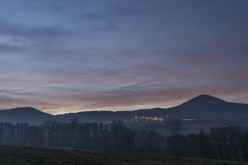 Sunrise under Milesovka hill in winter
