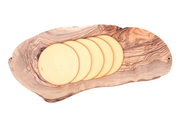 Sliced amish farm organic smoked gouda cheese on olive wood cutting board isolated on white background