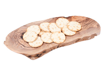 Pepper and poppy crackers on olive wood cutting board isolated on white background