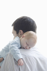 Newborn baby sleeping on father's shoulder over white background