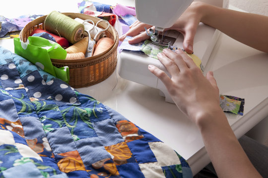 Cropped Image Of Woman's Hands Making Patchwork At Sewing Machine