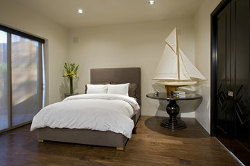 Interior of contemporary bedroom with boat model on side table