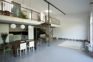 Spacious apartment with mezzanine and white wall - obrazy, fototapety, plakaty