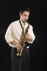 Obraz na płótnie Canvas Man playing saxophone isolated over black background