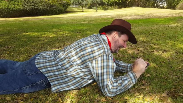 Cowboy browses at pictures on mobile phone