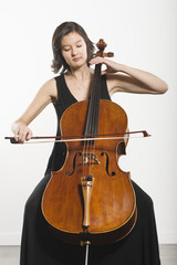 Beautiful young woman playing cello classical music instrument