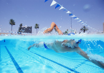 Young male athlete swimming in pool