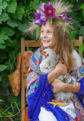 young girl holding a cock on  green background