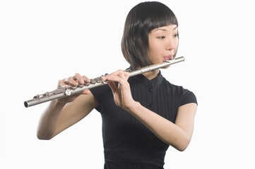 Beautiful woman playing flute isolated over white background © MDBPIXS