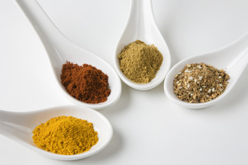 High angle view of various spices in spoons isolated over white background