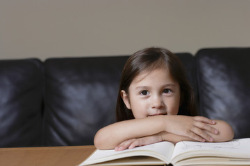 Closeup portrait of a young girl with book in living room