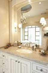 Marble topped cream bathroom with window reflected in mirror
