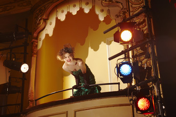 Low angle view of a cheerful young woman in theatre box
