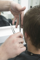 Closeup rear view of man getting haircut in hair salon