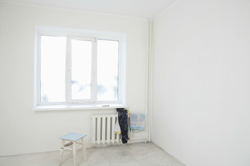 Dirty clothes on radiator under window of new apartment