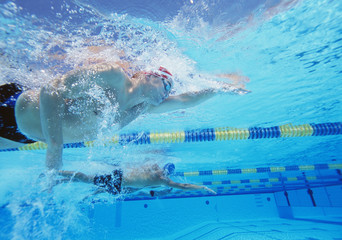 Fototapeta na wymiar Underwater shot of three male athletes in swimming competition