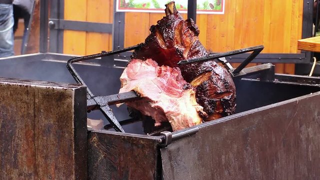 spit with meat that is cooking on the coals and the fire: rotisserie