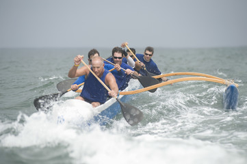 Crew of a racing outrigger canoe on water