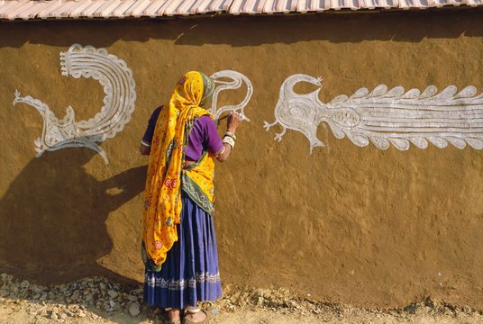 Woman decorating her house with traditional local designs, Tonk region, Rajasthan