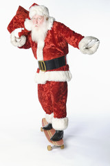 Man in Santa Claus outfit standing on skateboard carrying sack isolated over white background