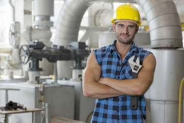 Portrait of young worker standing arms crossed in industry