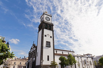 Obraz premium Saint Sabastian church with clock tower in Ponta Delgada on Sao Miguel Island in Azores, Portugal. Beautiful church in early morning under white clouds.
