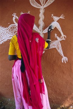 Woman decorating her house with traditional local designs, Tonk region, Rajasthan