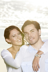 Portrait of happy woman with arm around man at beach