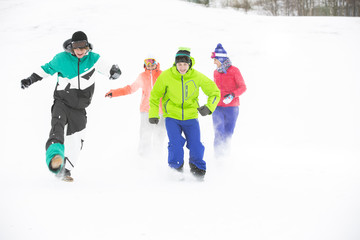 Full length of young friends having fun in snow