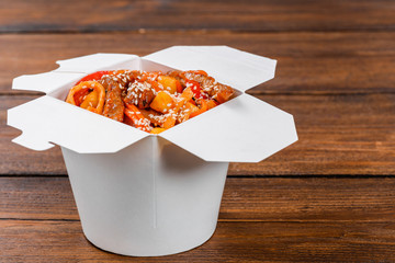 Noodles in a white box on wooden background