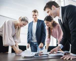 Happy young business people brainstorming at conference table