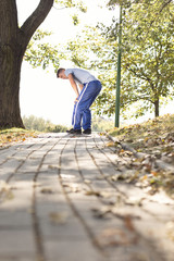 Fototapeta premium Full length of tired young man standing on path after running in park