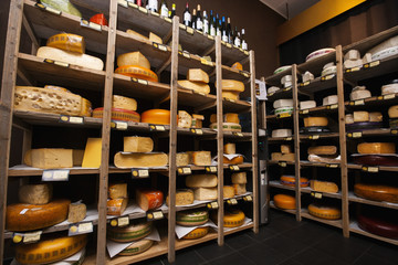 Fototapeta na wymiar Cheese arranged in shelves at store
